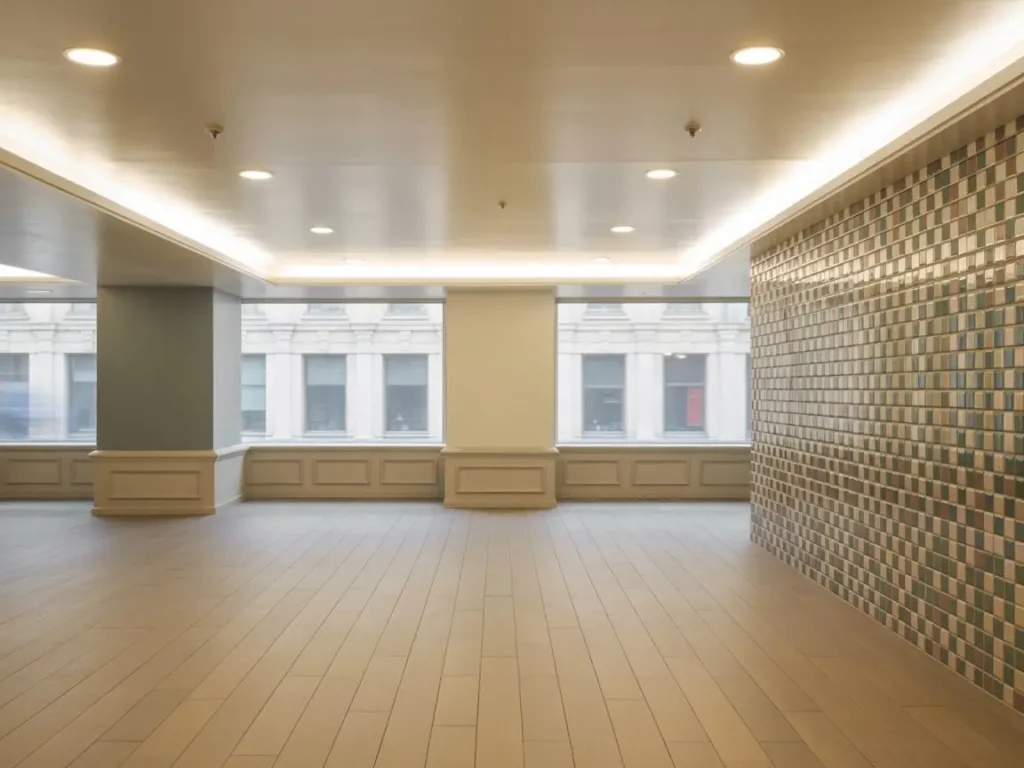 interior de local comercial con paredes de pladur, techo iluminado y suelo de madera clara