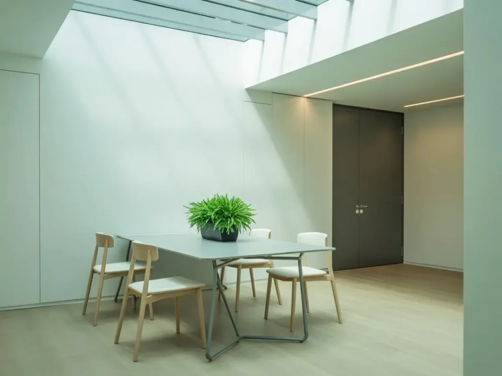 sala de reuniones luminosa con paredes de pladur y techo acristalado en oficina moderna